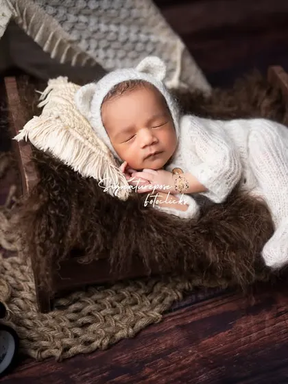 A cozy little bear cub fast asleep. Our rustic-themed newborn shoots use natural textures like wood, wool, and soft knits to create a warm and earthy feel.
