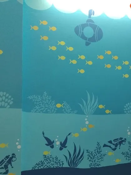 We created an enchanting underwater world in this kids' room. The multi-toned blue wall features stencils of fish, a submarine, and scuba divers, turning the entire room into an aquatic adventure.