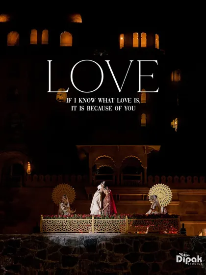 A kiss that seals a promise, framed by the historic architecture of Fairmont Jaipur. This wide shot, with the couple silhouetted against the night, emphasizes the romance and the grandeur of their love story.