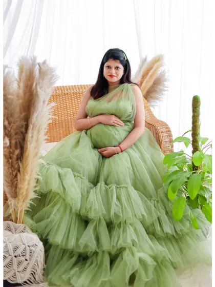 A seated portrait in a light green ruffled gown, set in our versatile boho studio space.