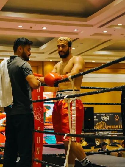 In the corner between rounds, giving strategic advice. A coach's job is to guide the fighter to victory.
