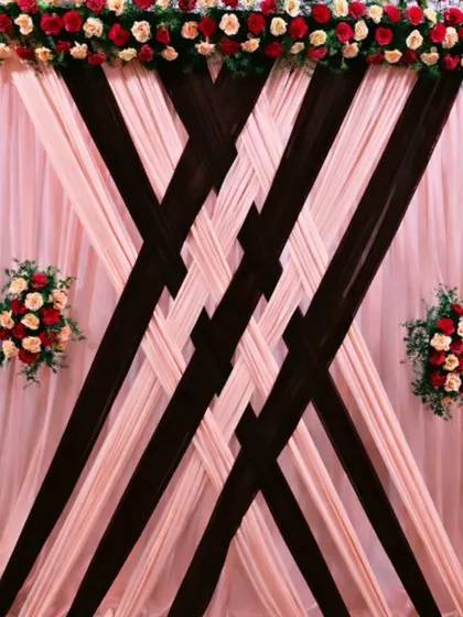 This backdrop combines soft blush pink and rich brown fabrics in an intricate braided pattern. I topped it with a line of fresh red and cream roses, creating a look of sophisticated elegance perfect for formal ceremonies.