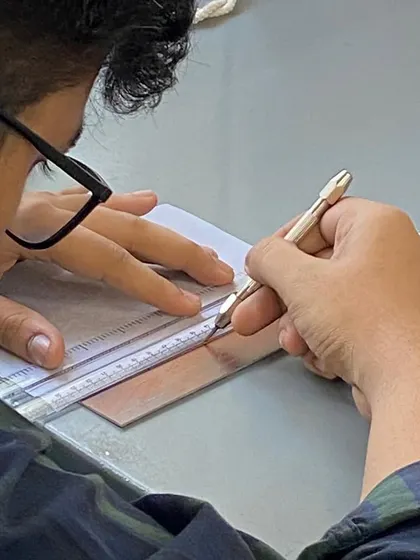 A student using a scribe to draw onto a prepared plate. The directness of this action, scoring a line into metal, is a powerful and expressive way to create an image.