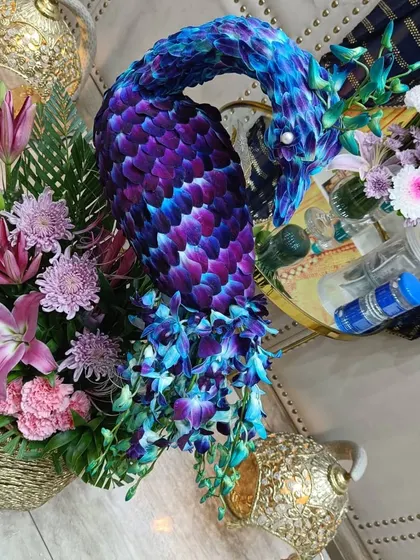 A close-up of the floral peacock art piece. You can see the detail here, with each petal of the blue and purple orchids carefully placed to create the peacock's feathers.
