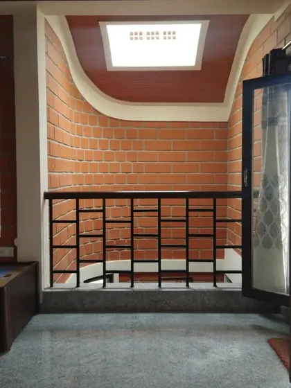 A small balcony or landing with a curved ceiling detail, lit by a skylight, creating an interesting architectural moment.