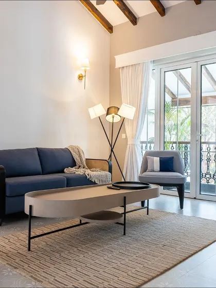 The TV lounge in the Goa villa, featuring a custom sofa with rattan details and a sleek, modern coffee table. The design balances comfort with a light, airy aesthetic.