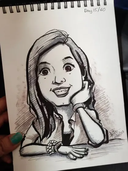 Another look at the smiling caricature, held in hand to show the scale of the sketchbook page.