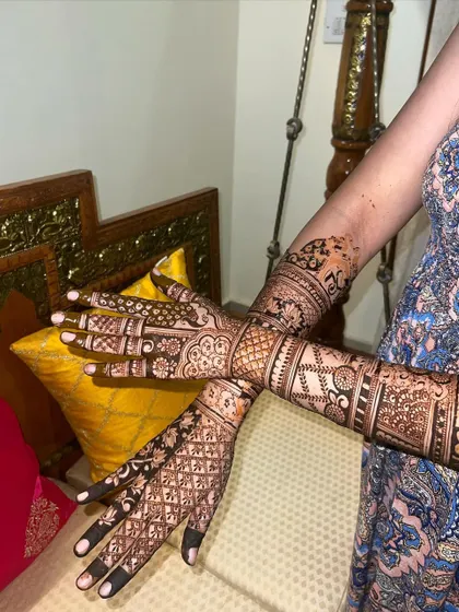 A full view of the intricate bridal mehendi, showing the detailed work from fingertips to elbows.