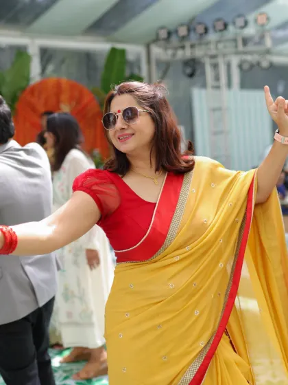 A guest raises her hand to the music as our Sheraton Grand Whitefield baby-shower set gets everyone involved.