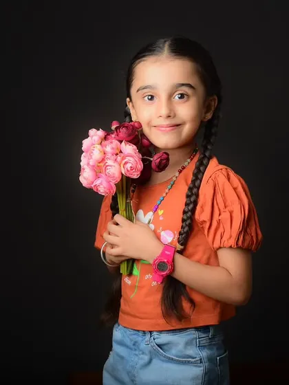A charming solo portrait of the daughter from a family shoot, holding a bouquet of flowers which adds a soft, lovely touch.