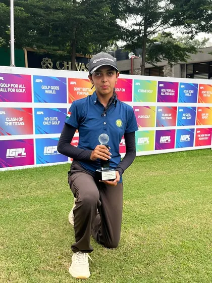 Smira Bhambri kneels on the green, holding her Runner-Up trophy from the IGU Chandigarh Junior Girls Championship. Her performance at the event was commendable.