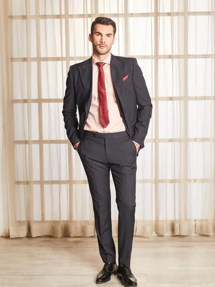 A full-length portrait of the double-breasted pinstripe suit. The silhouette is strong and masculine, tailored to create a flattering V-shape torso.