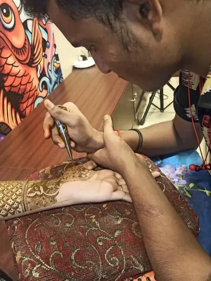 One of our professional artists applying an intricate henna design at a client's home. Our team provides a comfortable and hassle-free mehndi experience anywhere in Mumbai and Thane.