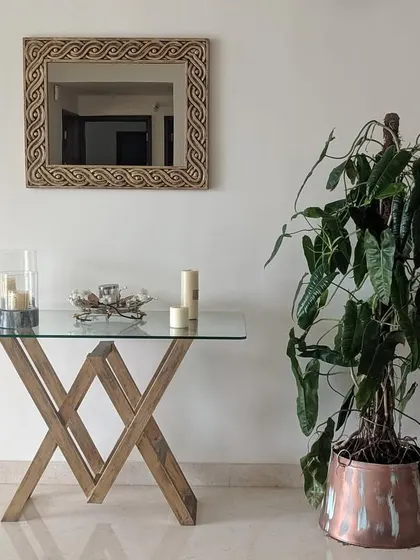 A tall Philodendron plant in a copper planter adds a touch of organic elegance to this entryway console. I help select indoor plants that fit the scale and style of your home decor.