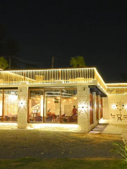 The cafe facade lit up at night, creating a warm and inviting atmosphere.