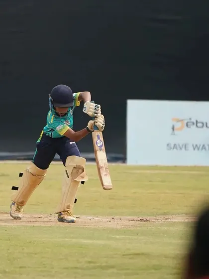 A batsman plays a powerful shot during a competitive match, demonstrating the skills developed through our training.