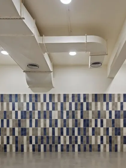 Even functional spaces like changing rooms were designed to be uplifting. We used a playful pattern of blue and grey tiles to create a visually engaging wall, moving away from a purely utilitarian aesthetic.
