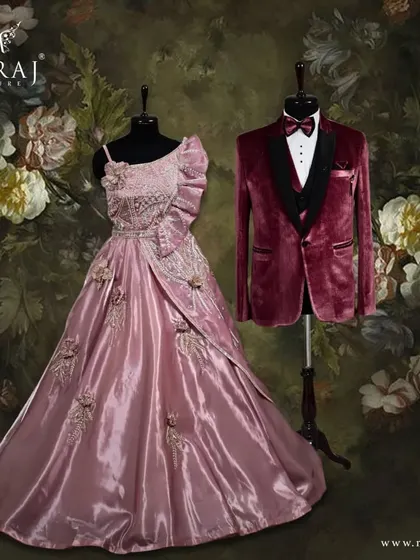 A coordinated look that radiates sophistication. The groom's classic red velvet suit is the perfect partner to the bride's beautifully patterned off-shoulder peach gown.