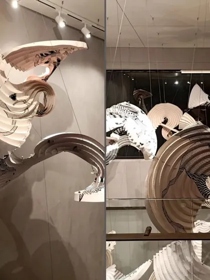 Two perspectives of the Gond art origami installation, showing its dynamic, curved forms and the interplay of shadow. The piece is a testament to our commitment to innovative collaborations that merge different craft traditions.