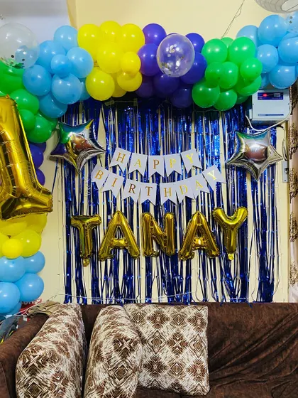 A different angle of the colorful first birthday decor, showing how the balloon arch frames the personalized backdrop.