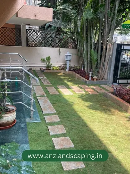 Another perspective of the completed Indiranagar project, highlighting the harmony between the green lawn, stone path, and the home's architecture.