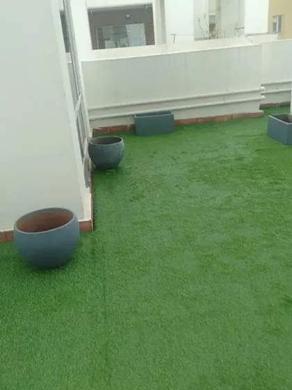 The result of a professional installation: a pristine and vibrant artificial lawn, ready for planters and furniture.