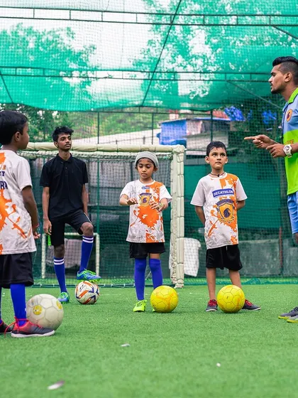 A coach giving instructions to a group of young, attentive football players. I believe in clear communication and personalized feedback.