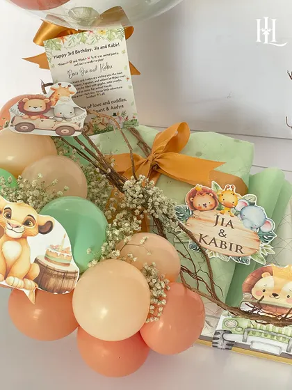 A closer look at the safari-themed birthday hamper, with custom name cutouts, adorable animal graphics, and a mix of balloons and gifts, all in a cohesive and playful color palette.