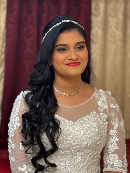 Another beautiful shot of the bride in her white gown. The side-swept hair and delicate hairpiece add a touch of modern elegance to her look.
