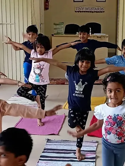 A group of children practicing the tree pose together. Group yoga sessions like this encourage balance, concentration, and a sense of shared accomplishment.