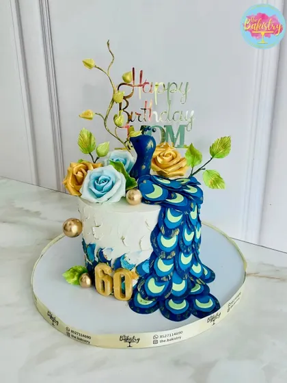 A regal treat for a queen's 60th birthday! This stunning peacock cake features a cascade of vibrant, handcrafted feathers and beautiful sugar flowers.