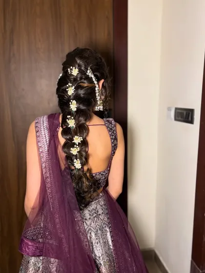 A beautiful braided hairstyle with small white flower accessories. This is a versatile look that works for both brides and bridesmaids.