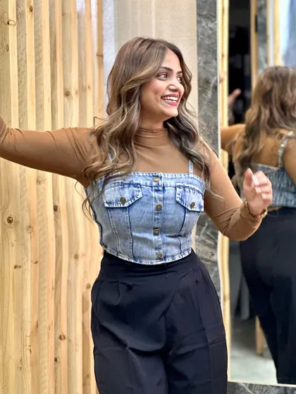 A happy client posing with her new balayage. The color brightens her complexion and the soft waves add a touch of glamour.