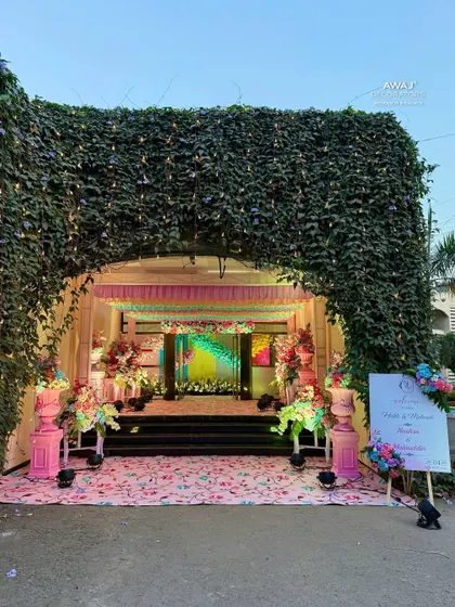A grand entrance arch made of natural ivy, leading into the pastel-themed celebration.