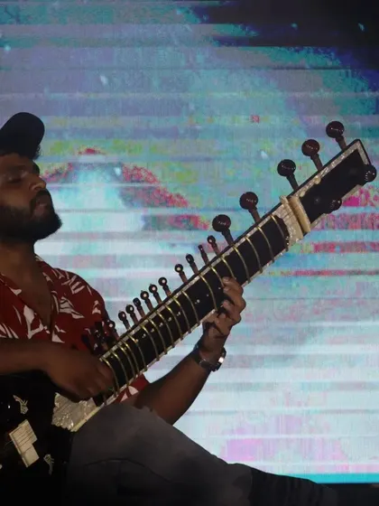 A close-up from a contemporary music festival. The modern shirt and cap are part of the casual, accessible vibe I bring to my fusion performances.