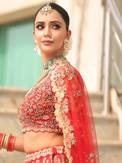 A side profile of the Ishq bride, showcasing her sleek bun with fresh flowers and the intricate embroidery on her blouse.