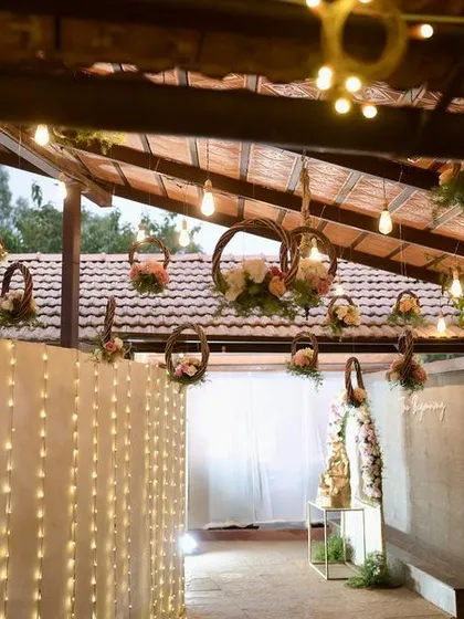 A breathtaking blend of luxury and nature. For this reception entrance, we combined the grandeur of crystal lights and a fairy light wall with hanging floral baskets.