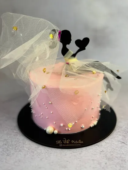 A "bride-to-be" cake perfect for a bridal shower. The design features a silhouette of a bride with a delicate, flowing veil made of edible fabric.
