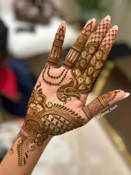 An elegant back-of-hand design with a peacock motif. The feathers are designed to flow beautifully with the shape of the hand.
