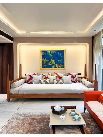 We created a modern 'baithak' or family seating area in the Palm Springs Villa, featuring a classic wooden daybed. This space is designed for informal gatherings, blending traditional Indian living concepts with contemporary aesthetics.