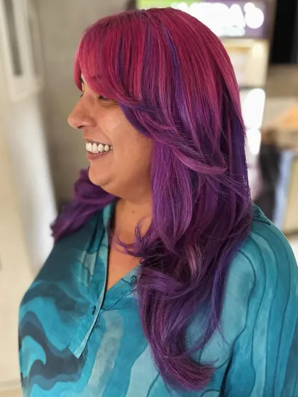The smile says it all. This pink and violet color with curtain bangs is all about expressing personality and having fun with your hair.