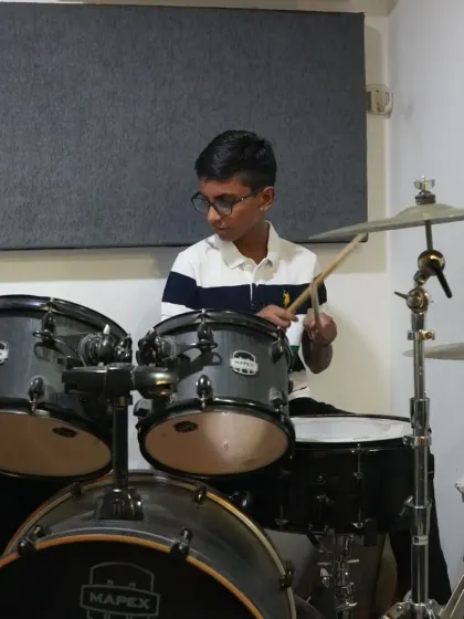 A young student focused during his drum lesson. Our practice rooms are where the hard work happens, building the skills and discipline needed for the stage.