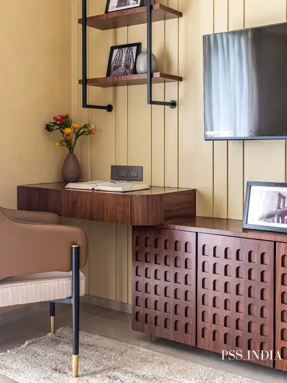 This study area is a perfect blend of form and function. A floating wooden desk is paired with a stylish armchair, while open shelving and a textured cabinet provide plenty of storage.