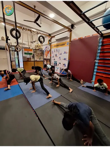 Students perform various advanced stretches in our gymnastics facility. This kind of training is essential for developing the flexibility needed for high kicks and agile movements.