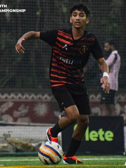 A player maintains control of the ball while under pressure from a defender.