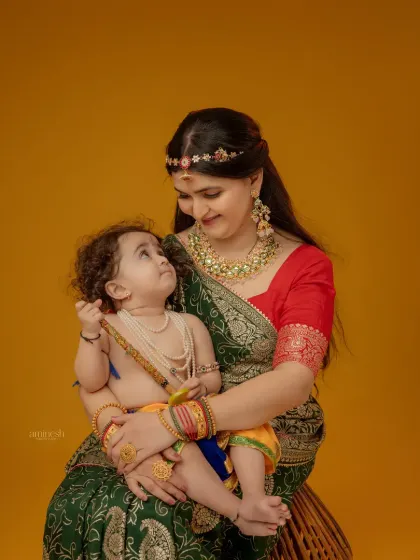 A tender moment between mother and child during the Yashoda and Krishna themed shoot. The baby looks up at his mother, creating a beautiful, emotional photograph.