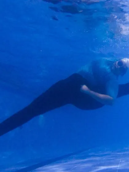 A duplicate view of the underwater split, showing the challenge of maintaining form without gravity's usual help. It’s a fun way to work on flexibility and core stability.