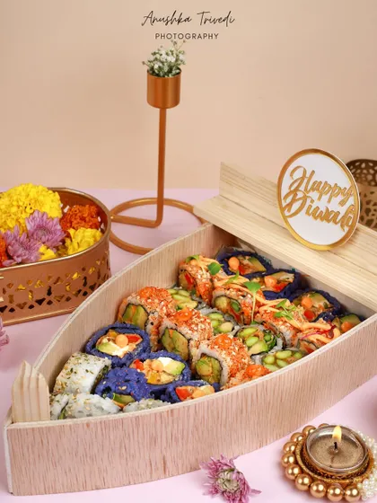 A unique boat-shaped sushi platter for Diwali, blending Japanese cuisine with Indian festive decor for a memorable fusion concept.