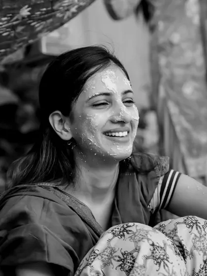 The pure joy of a Haldi ceremony captured in a timeless black and white photograph. Her radiant smile says it all, a moment of sheer happiness surrounded by loved ones.