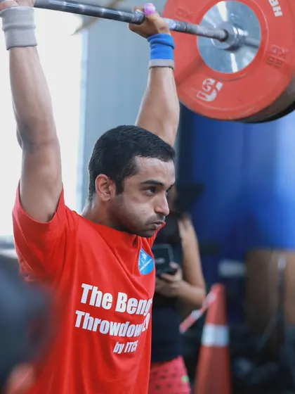 The focus and determination required for a heavy lift during competition. This athlete is locked in, ready to execute a perfect shoulder-to-overhead.